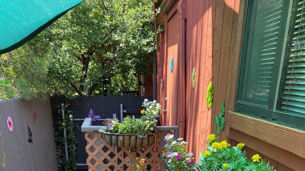 A small, enclosed garden area with various potted plants and a wooden lattice structure. - Secret Garden in gorgeous Sedona with AC, WiFi (Sedona)