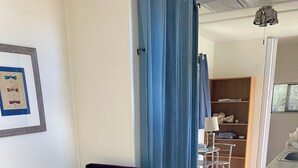 A room with two purple armchairs, a small wooden table, a colorful rug, a framed picture on the wall, and a glimpse of a dining area with a table and chairs. - Secret Garden in gorgeous Sedona with AC, WiFi (Sedona)