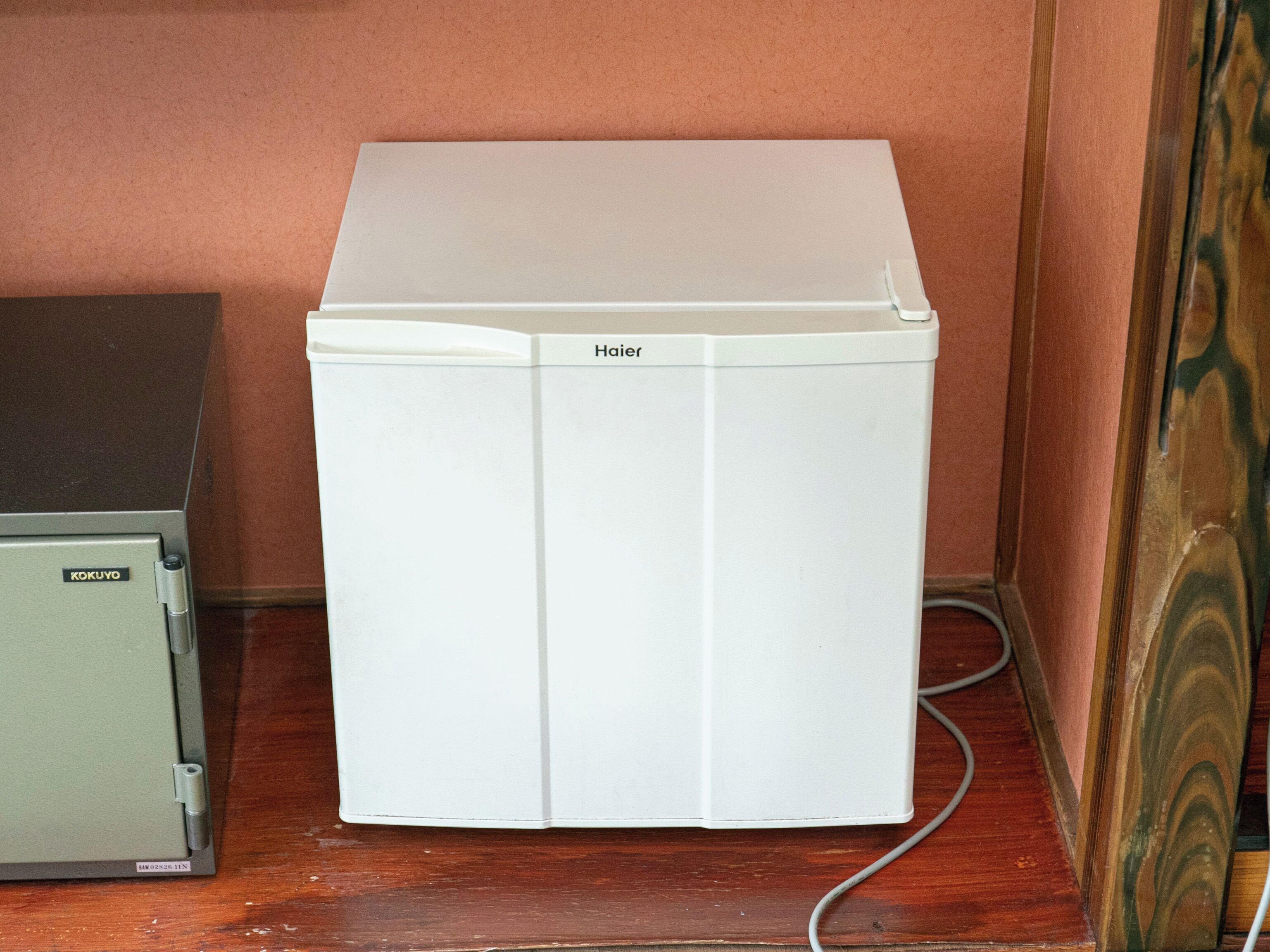 A white refrigerator with the brand name 'Haier' on the top.