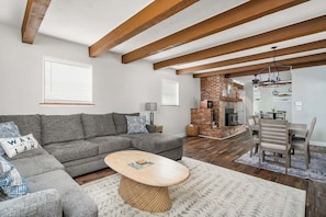 A living room with a sectional sofa, a coffee table, and a fireplace.