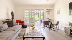 Una sala de estar moderna con sofá, mesa de centro y comedor.