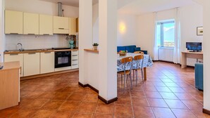 A compact kitchen with a dining area, a TV, and a window with a view. - Nice apartment for 4 people with WIFI, TV and patio (Musso)