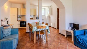 A compact living space with a dining area, kitchen, and seating area.