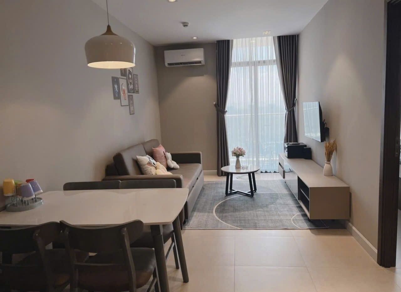 A modern living room with a sofa, dining table, and a small coffee table.