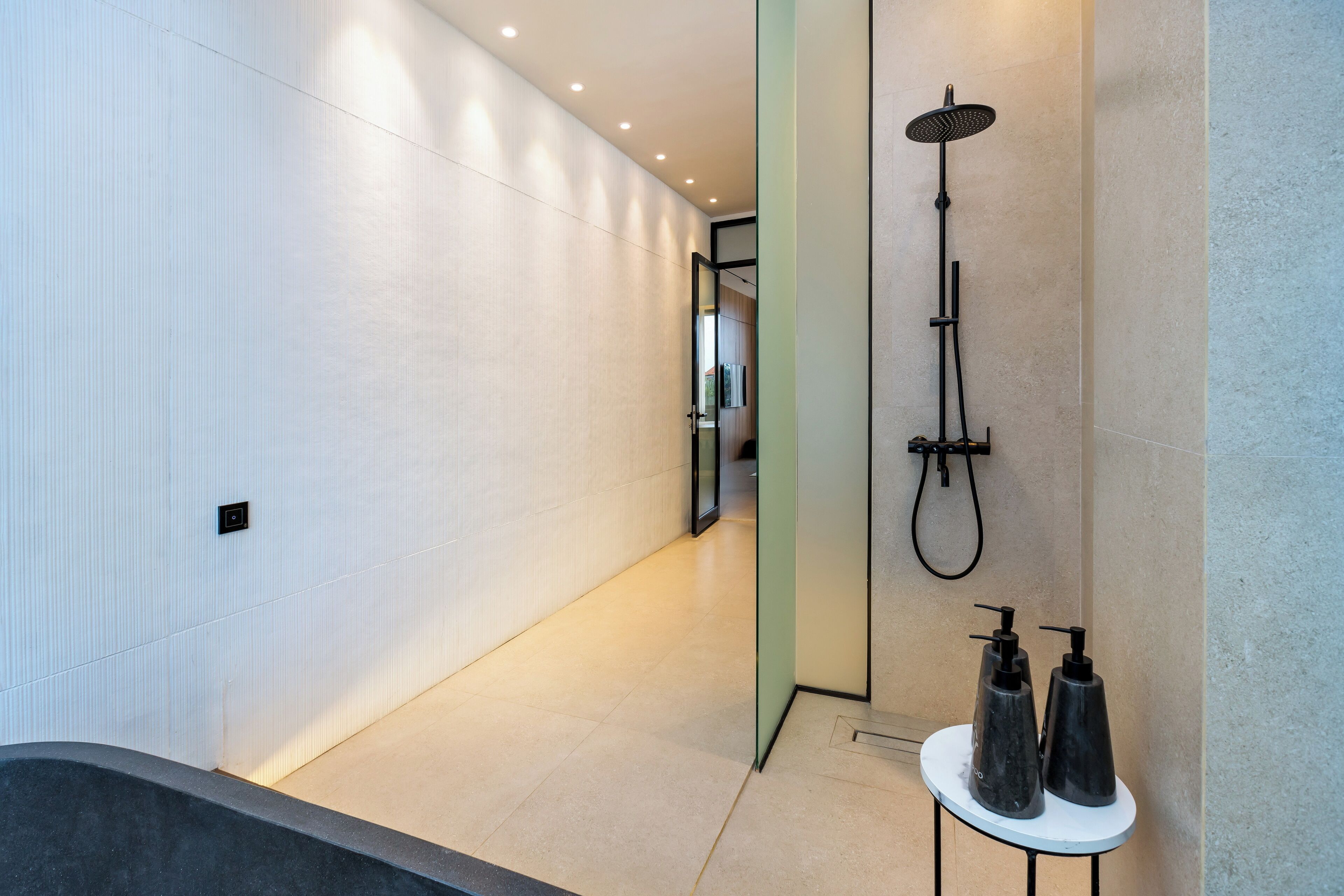 A modern bathroom with a bathtub, a shower, and a small table with toiletries.