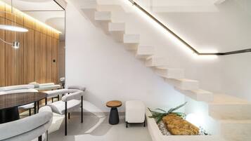 Un intérieur moderne avec un escalier, une table ronde et des sièges.