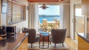Una cocina moderna con vistas al mar, un comedor con sillas y una mesa.