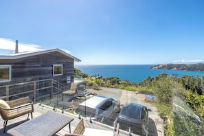 A modern house with a balcony overlooking a scenic ocean view. - Ocean Belle Onetangi (Waiheke Island)