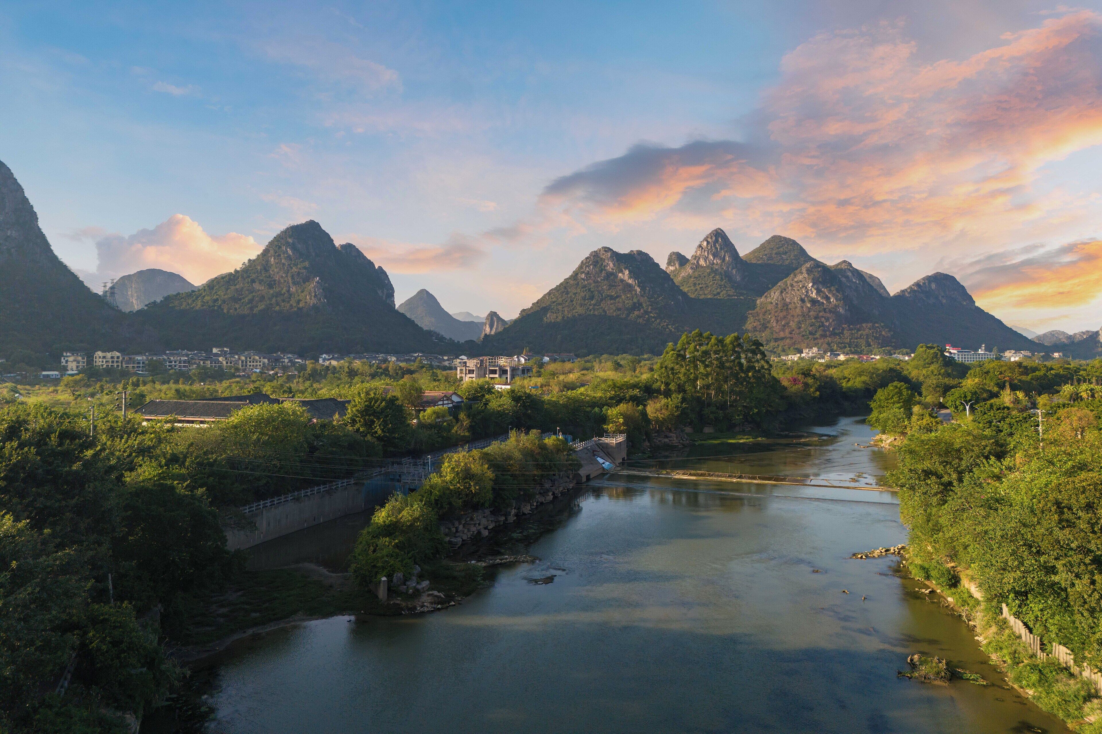 Un río serpenteando por un valle con montañas al fondo.