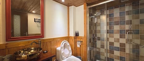 Une salle de bain avec un meuble-lavabo en bois, un grand miroir, des toilettes et une douche à parois de verre.