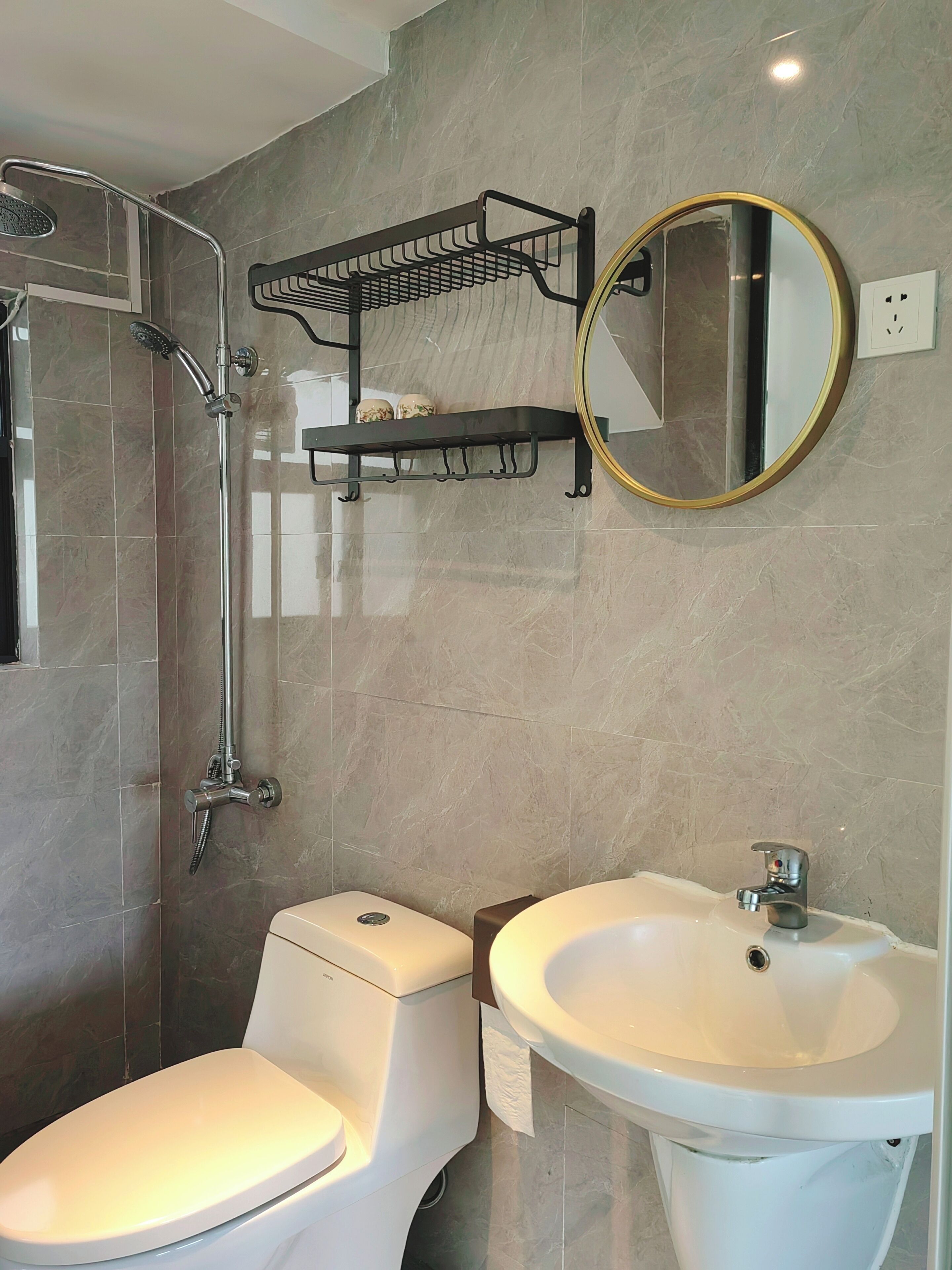 Ein Badezimmer mit Dusche, Toilette, Waschbecken und Handtuchhalter.