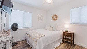 Una camera da letto con un letto, un comodino, una lampada e un elemento decorativo a parete.