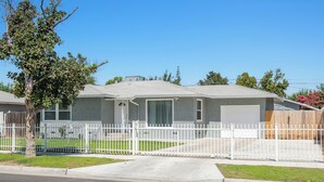 A single-story house with a front yard, a white picket fence, and a garage. - Upgraded 2Bed/1B on Quiet Street w. Easy Access  to US99 (Fresno)