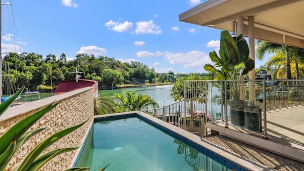 A swimming pool with a view of a river and greenery.