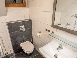 Un baño con inodoro, lavabo y espejo.