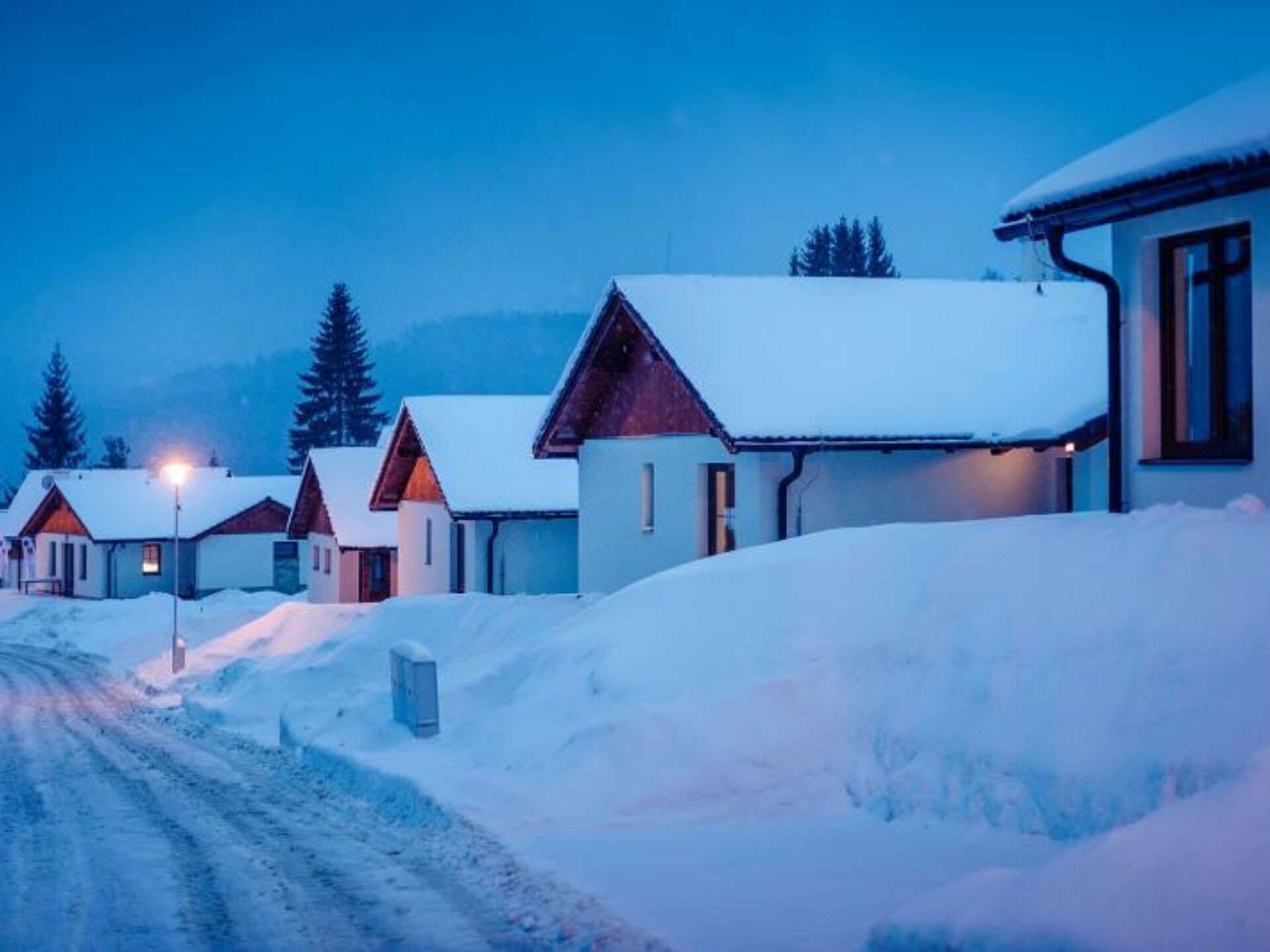 A row of snow-covered houses with a clear sky.
