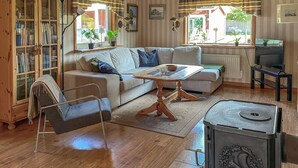 Ein gemütliches Wohnzimmer mit Sofa, Couchtisch, Fernseher und Kamin.