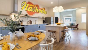 Une cuisine moderne avec un îlot central, des meubles blancs et un panneau indiquant « Bienvenue à Nashville ».