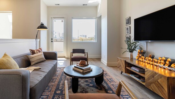 Un salon moderne avec un canapé, une table basse et un meuble pour la télévision.