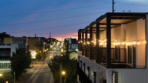 A street view at dusk with illuminated street lamps and buildings. - The Conway (Nashville)