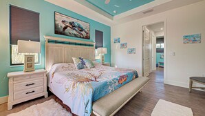 A bedroom with a bed, nightstands, a white fur rug, and artwork on the walls. - Amazing Octopus | Pool | Spa | outdoor Bar | Office (Placida)