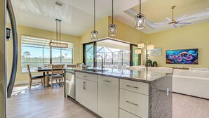 A modern kitchen with a large island, pendant lights, and a ceiling fan. - Amazing Octopus | Pool | Spa | outdoor Bar | Office (Placida)