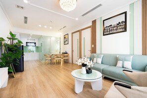 Ein modernes Wohnzimmer mit einer Couch, einem Glastisch und einem Essbereich mit Stühlen und einem Tisch.