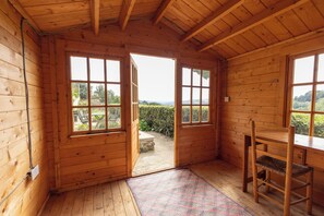 A wooden cabin with a large window and a wooden chair. - The Dormers - Amazing Views & Space (Stroud)