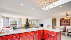 A spacious kitchen with a large island, red cabinetry, and a chandelier. - Scenic Home w/ Sauna - 7 Mi to Heavenly Mountain! (Kingsbury)
