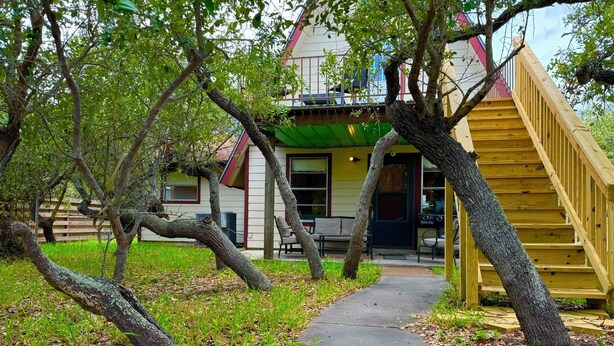 A pathway leading to a house with a green roof and a red and white exterior. - Spacious 4-bedroom house in charming Rockport with AC, WiFi BAR  (Rockport)