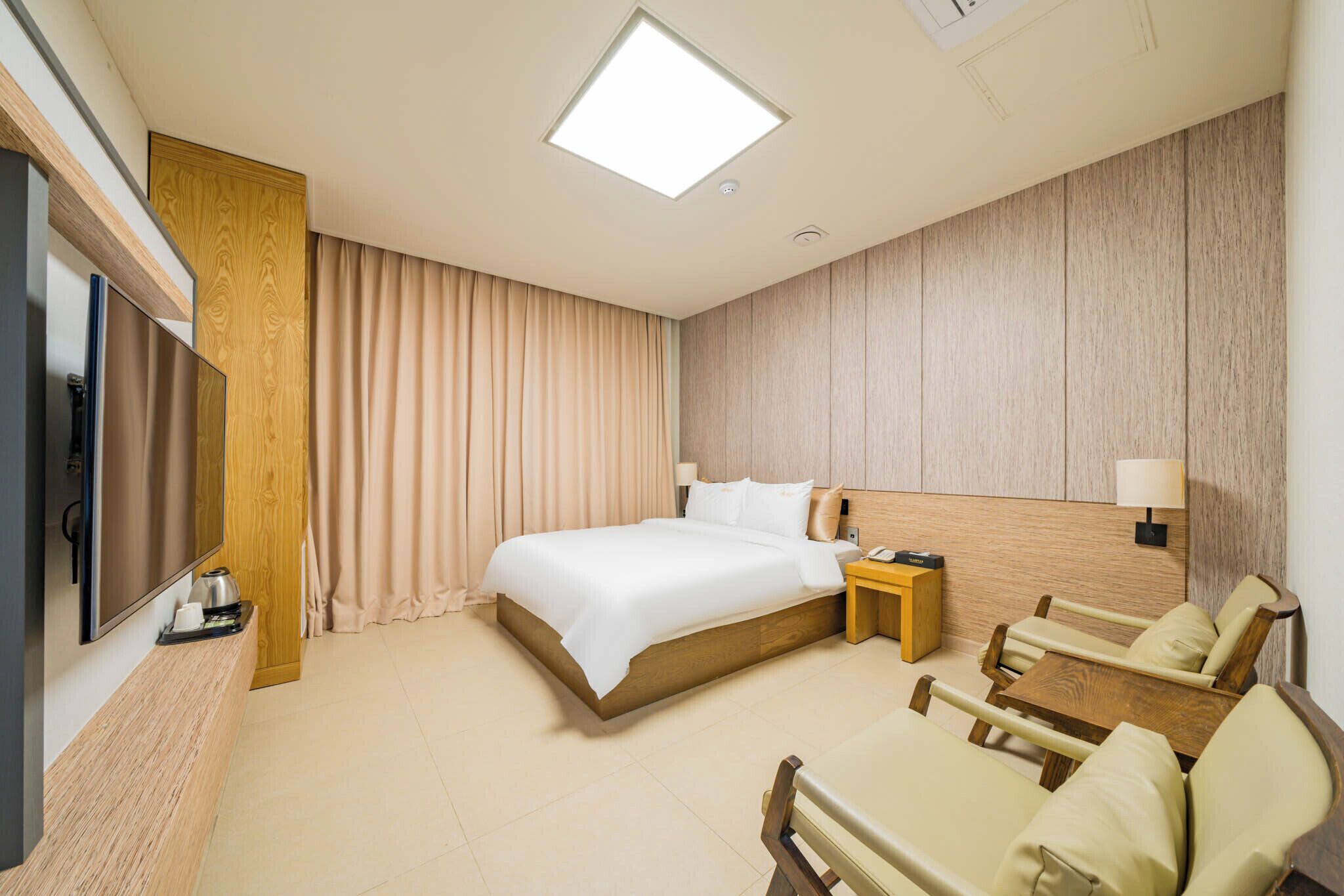 Una habitación de hotel con cama, televisión, escritorio y silla.