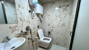 Un baño con lavamanos, inodoro y ducha.