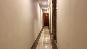 Un pasillo con suelo de mármol y puertas de madera.