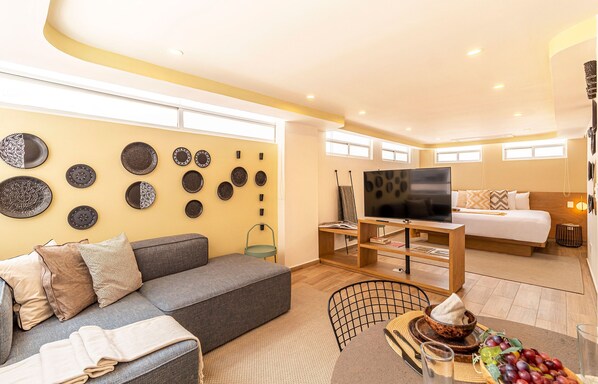 Relax in this stylish living room with a comfortable sofa, dining table, and flat-screen TV.
