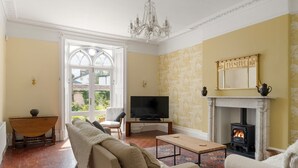 A living room with a fireplace, television, and seating area. - Grade II Listed House in Central Exeter (Exeter)