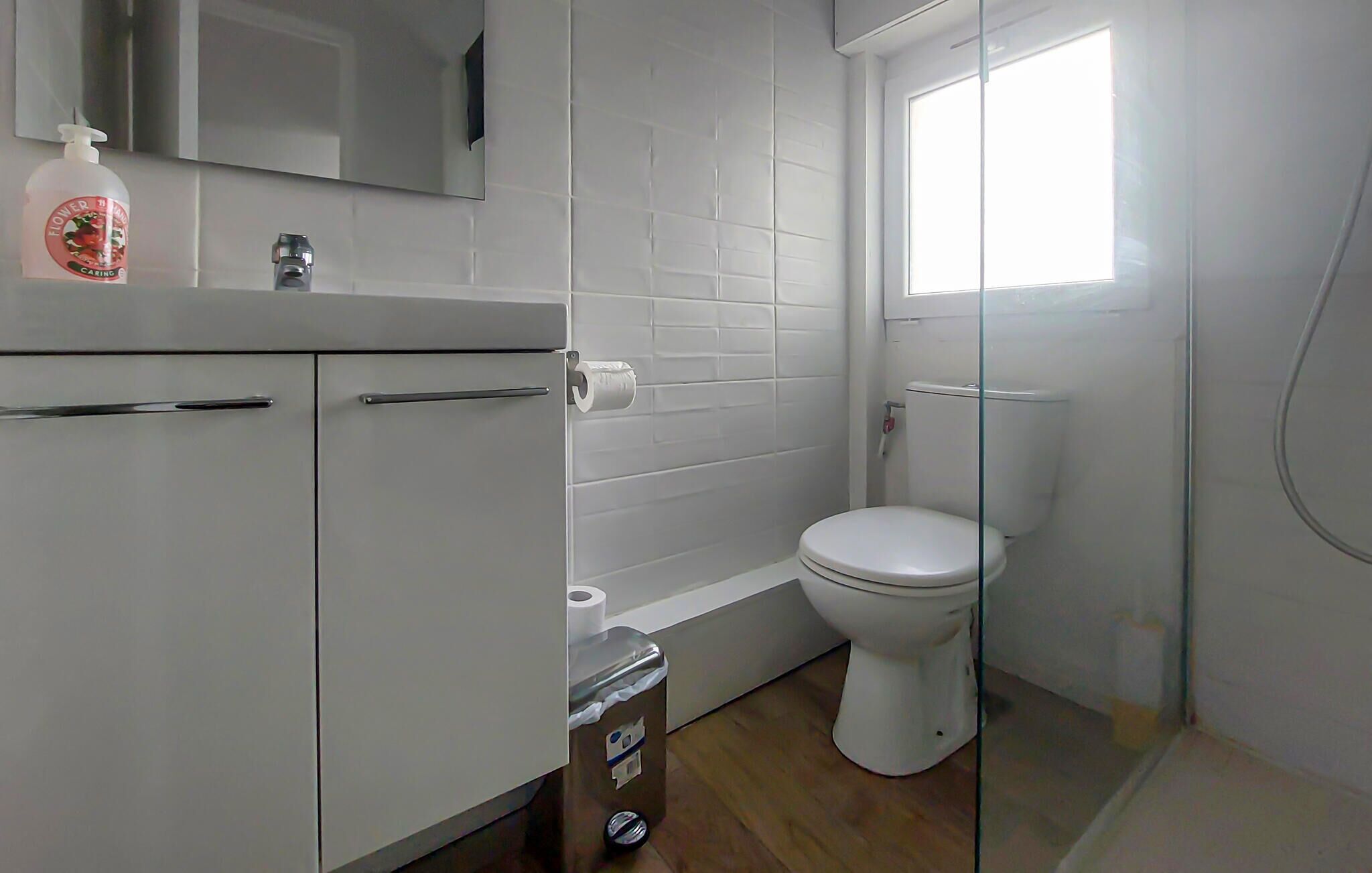 Ein Badezimmer mit Toilette, Waschbecken, Spiegel und Fenster.