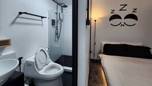 Une salle de bain moderne équipée de toilettes, d’un lavabo et d’une douche.
