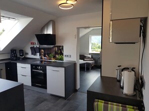 Una cucina compatta con elettrodomestici moderni, una zona pranzo con vista e un piccolo angolo living.
