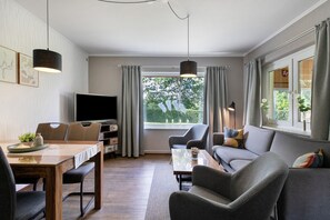 A modern living room with a television, seating, and a large window. - Apartment 'Ferienwohnung Sawade' with Private Terrace, Shared Garden and Wi-Fi (Schafstedt)