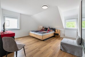 Ein Schlafzimmer mit Hochbett, Schreibtisch, Stuhl und Sitzbank.