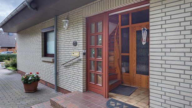 A brick building with a red door, a window, and a potted plant. - Apartment 'Haus Stoldt, Wohnung 1' with Shared Terrace, Shared Garden and Wi-Fi (Meldorf)