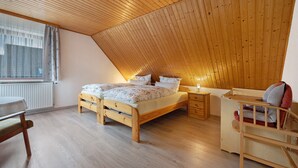 A bedroom with a sloped ceiling, a bed, a desk, and a chair. - Apartment 'Haus Stoldt, Wohnung 1' with Shared Terrace, Shared Garden and Wi-Fi (Meldorf)