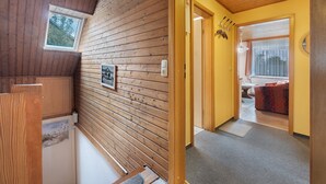 A wooden interior with a door leading to a living area, a window, and a radiator. - Apartment 'Haus Stoldt, Wohnung 1' with Shared Terrace, Shared Garden and Wi-Fi (Meldorf)