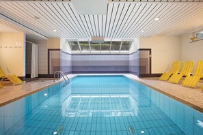 A swimming pool with tiled walls and a skylight.