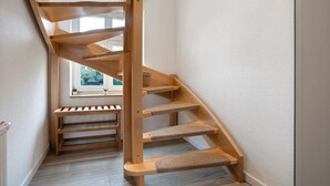 A wooden spiral staircase with built-in shelves and a window at the top. - Apartment 'Bäckerhus - Ferienwohnung 4' with Private Terrace, Shared Garden and Wi-Fi (Wiek)