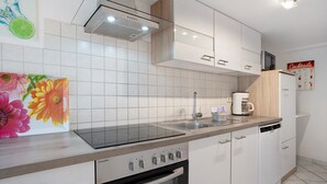 Een moderne keuken met een vaatwasser, fornuis en magnetron.