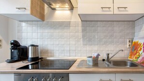 Una cucina moderna con forno a incasso, macchina del caffè e lavello.