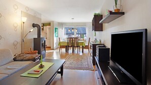 Una sala de estar moderna con sofá, televisor y comedor.