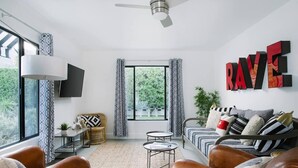 Un salon moderne avec un canapé, une table basse et un téléviseur fixé au mur.