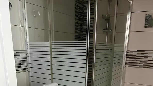 A compact bathroom with a glass shower enclosure, a white washing machine, and a tiled floor. - Sea view studio with balcony, 2 steps from the beach (Mogán)